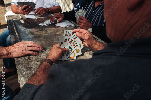 MARTINA FRANCA, ITALY / SEPTEMBER 2019: Old mens playing traditional card game in the parc