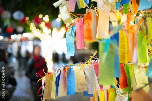 Wishes written on Tanzaku, small pieces of paper, and hung on a Japanese wishing tree, located in the Little Tokyo section of Los Angeles, California, photographed at an outdoor mall at night. 