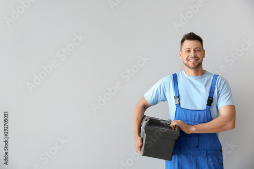 Portrait of handsome plumber with tools box on white background