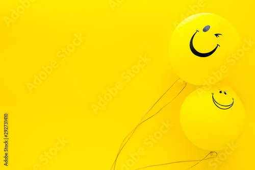 Happiness emotion. Yellow balloon with smile on yellow background top view space for text