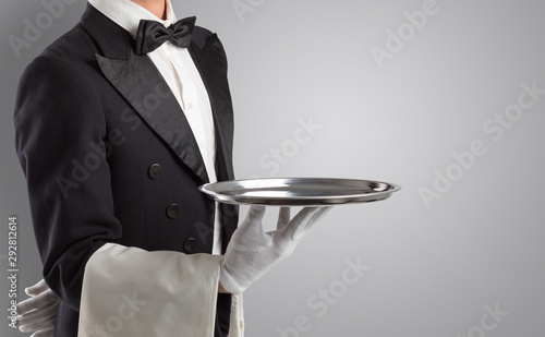 Waiter serving with white gloves and steel tray in an empty space