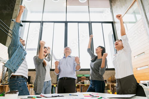 Cheerful group of creative business people winning great successful stretegy achievement in meeting room office background