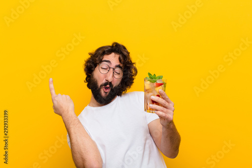 young crazy bearded man with a cocktail. tourist concept