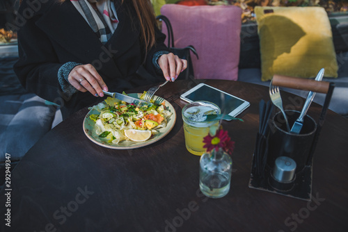 woman in cafe eating salad hands close up no face