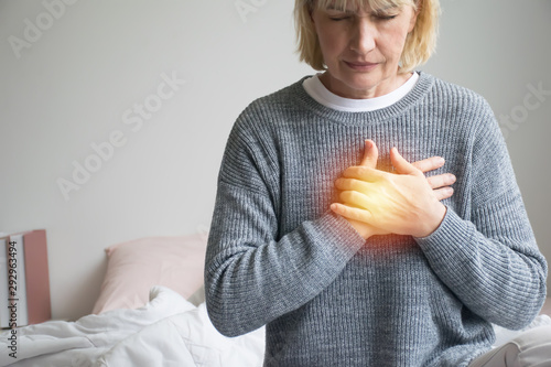 woman experiencing discomfort in his chest.Heart attack with woman clutching his chest.Severe heartache.woman suffering from chest pain. 