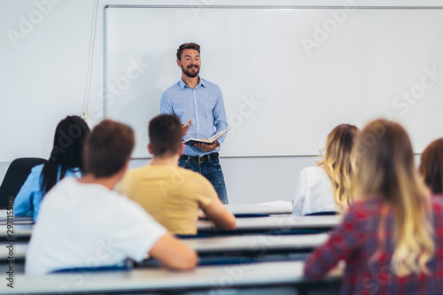 Young students listening to professor in the classroom on college
