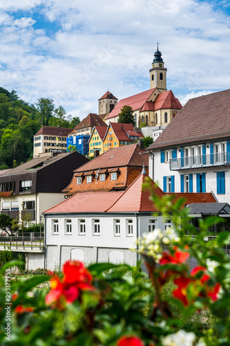 Germany, Beautiful church and old town of city horb am neckar on sunny day behind colorful red flowers