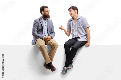 Men sitting on a banner and talking