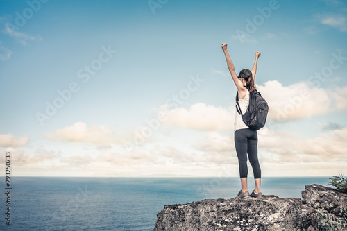 Reaching the top of a mountain. Woman hike celebrating triumph and victory. 