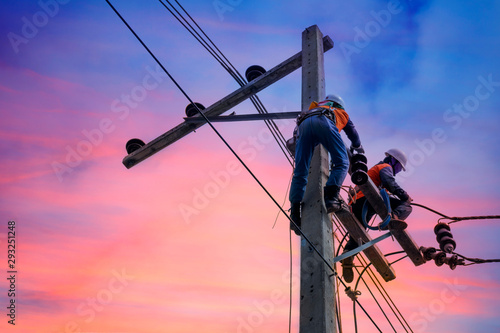 Electrician lineman repairman worker at climbing work on electric post power pole