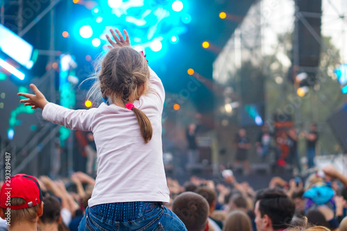 Children sit around the neck at a street concert