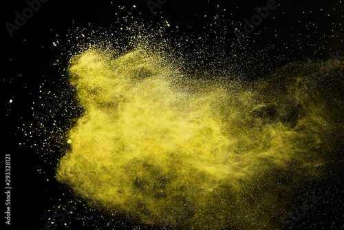 Yellow powder explosion on black background. Paint Holi.