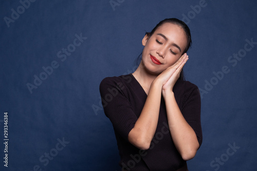 Beautiful young Asian woman with sleeping gesture.