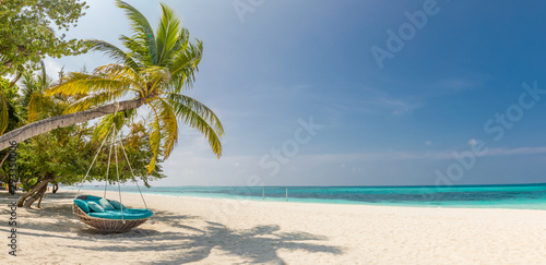 Panorama tropikalnej plaży jako letni krajobraz z huśtawką lub hamakiem i białym piaskiem i spokojnym morzem na baner plażowy. Idealna koncepcja na wakacje i wakacje na plaży. Popraw proces koloru