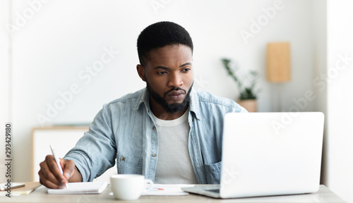 Unemployed man using laptop searching for vacancies online in internet