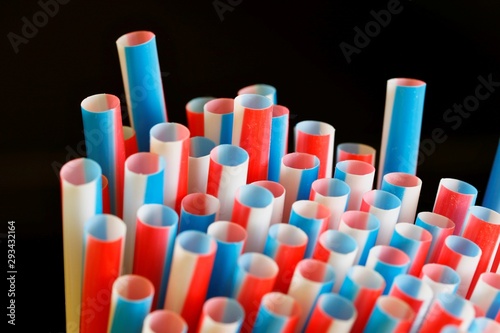 Pack of colorful drinking straws on a dark black background in landscape orientation