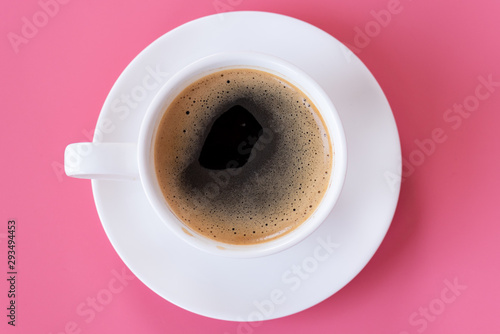 Top view of hot coffee and foam in white cup isolated on pink background and copy space.Coffee menu in the coffee shop or restaurant.