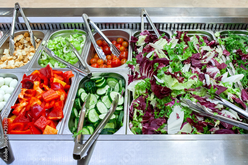 Fresh salad bar with various fresh assortment of ingredients. Display space of options for choice of clients in supermarket or restaurant