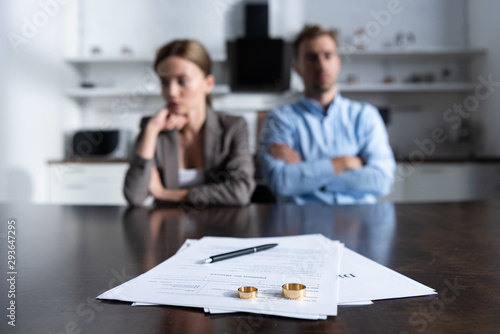 selective focus of couple sitting at table with divorce documents