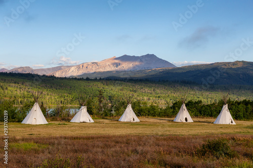 Beautiful View of the Tipi in a field with American Rocky Mountain Landscape in the background during a sunny summer morning. Taken in Montana near Glacier National Park, USA.