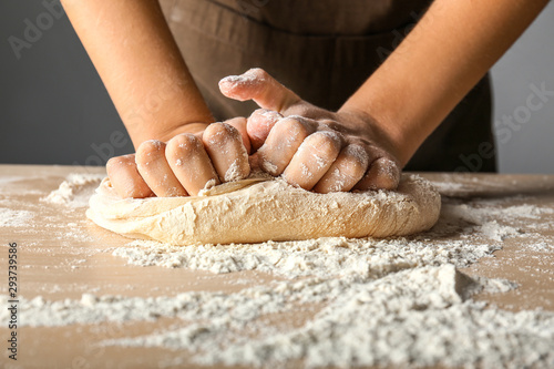 Woman kneading flour in kitchen, closeup