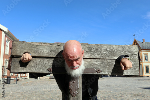 Bearded, bald man in a pillory, Old Town, Fredrikstad, Norway