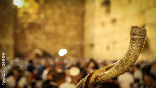 Shofar and in the background religious people pray at the Western Wall in the Holy City of Jerusalem in Israel