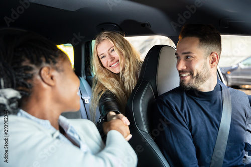 Female Friends Shaking Hands Inside Car