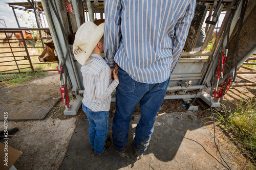 Cowboy father and son working on ranch