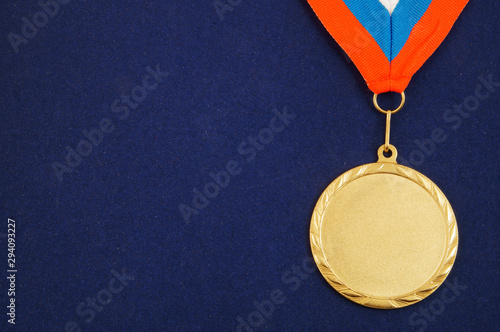 Gold medal with ribbon on blue velveteen