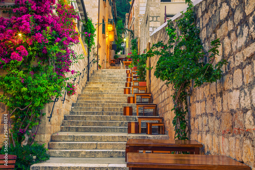 Narrow street and street cafe decorated with flowers, Hvar, Croatia