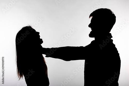 Domestic violence and abuse concept - Silhouette of a man asphyxiating a woman