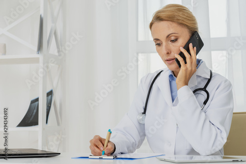 Doctor talking on the phone sitting at desk