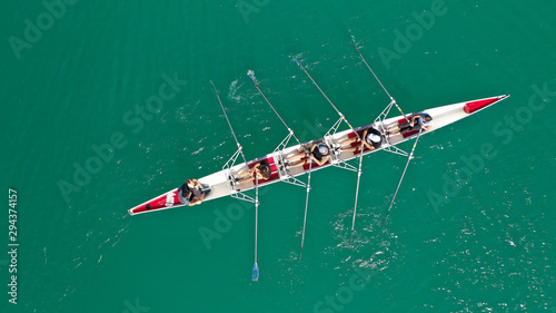 Aerial drone photo of team of Athletes rowing in sport canoe in tropical exotic lake