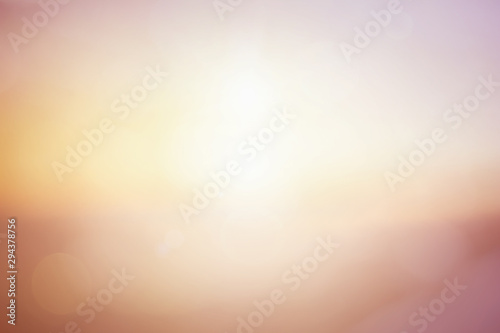 Natural background blurring warm colors and bright sun light. Bokeh or Christmas background Green Energy at sky sunny color orange light patterns plain abstract flare evening clouds blur.