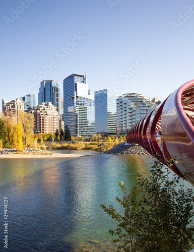 Calgary city view over the Bow river by Peace bridge with some fall foliage and buildings