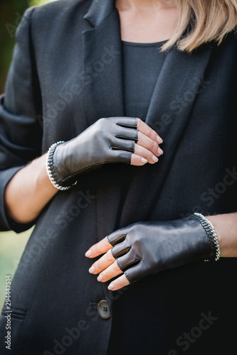 woman in a black jacket and gloves with a chain, close-up