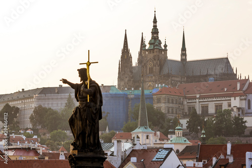 Sculpture of John the Baptist on Charles bridge against the Prague castle.