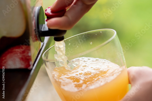 Vacuum boxed apple juice being poured into a glass.