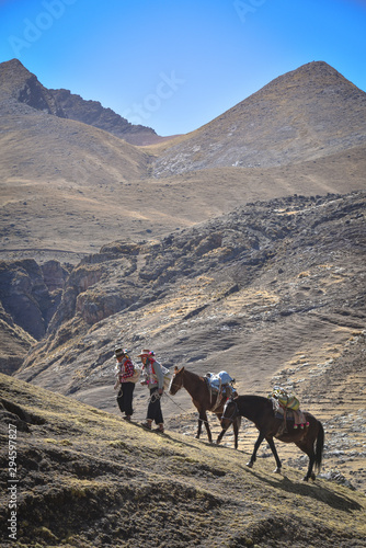 Horsemen in traditional Quechua dress following trails through the Andes. Ausungate trail, Cusco, Peru