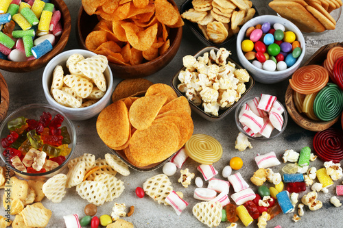 Salty snacks. Pretzels, chips, crackers and candy sweets on table