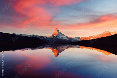 Splendid landscape with colorful sunrise on Stellisee lake. Snowy Matterhorn Cervino peak with reflection in clear water. Zermatt, Swiss Alps