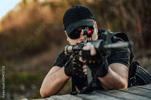Close-up image of man aiming with sniper rifle.
