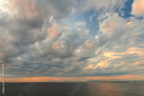  cumulus clouds in the rays of the setting sun over the ocean near the mountains