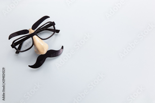 Carnival mask with moustache, nose and glasses on grey background, copy space. Concept Movember, men's health, prostate cancer awareness month, charity, Father's Day. Horizontal. Minimalism flat lay