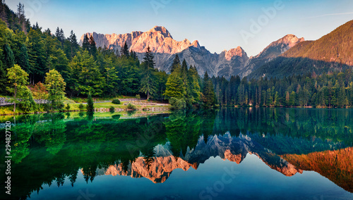 Spokojny poranek widok na jezioro Fusine. Kolorowy lato wschód słońca w Juliańskich Alps z Mangart szczytem na tle, prowincja Udine, Włochy, Europa. Piękno natury pojęcia tło.