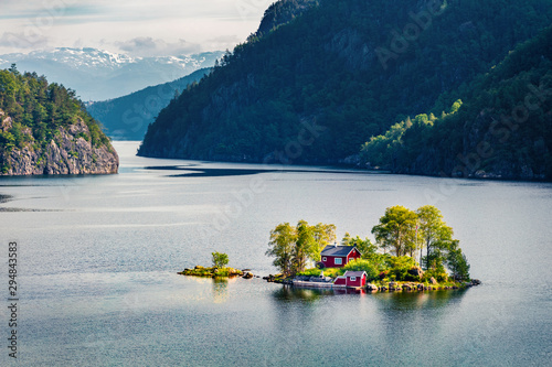 Magnificent summer view with small island with typical Norwegian building on Lovrafjorden flord, North sea. Colorful morning view in Norway. Beauty of nature concept background.