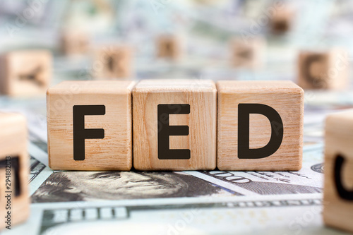 FED - acronym from wooden blocks with letters, abbreviation FED Federal Reserve System or federal agent concept, random letters around, money background