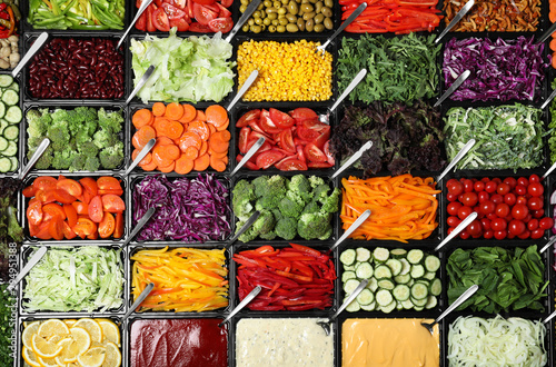 Salad bar with different fresh ingredients as background, top view