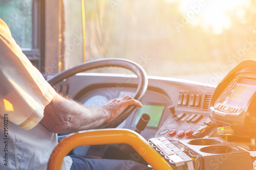 Hands of driver in a modern bus by driving. Concept of bus driver steering wheel and driving passenger bus. Toning. 